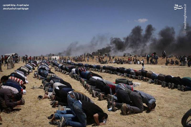 عکس/ اقامه نماز فلسطینی‌ها در میان آتش و دود